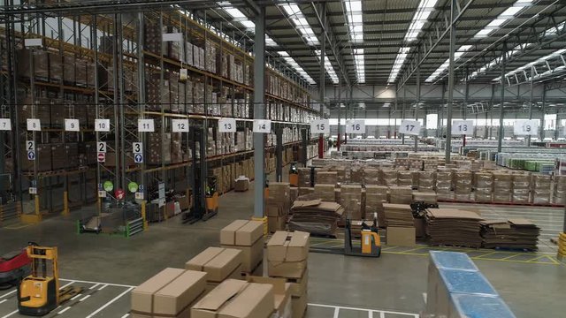 Interior of large stock warehouse with multiple shelves and stacks of inventory
