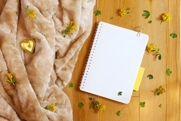 Flat lay of blank notepad and yellow barberry flowers on wooden background