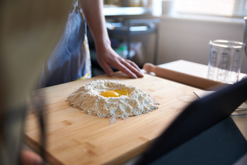 Anonymous Person Making Fresh Pasta At Home in The Kitchen, Watching A Video Recipe