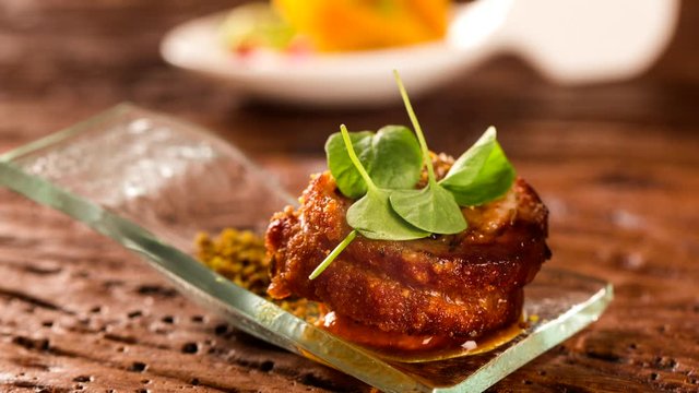 Slide shot Pork ballotine with pururuca, water flour, pumpkin puree and sprouts in a spoon. Taste gastronomy finger food wit smoke.
