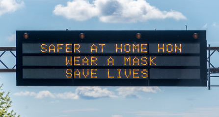 Safer at home, wear a mask sign over highway 32 in Maryland with a Baltimore 