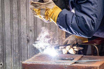 Metal welding by a manual electric welding machine.