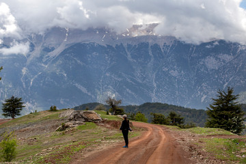 Fototapeta premium A woman photographer watching the landscape in the mountains of Antalya