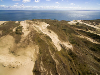 Aerial view with dunes, forest and sea in Curonian spit on a sunny day photographed with a drone. The Curonian Spit lagoon. Gray Dunes, Dead Dunes. 