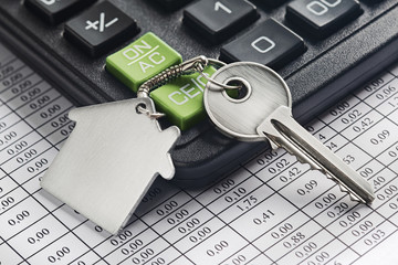 Real estate, keychain with house symbol. Calculator with finance blank.