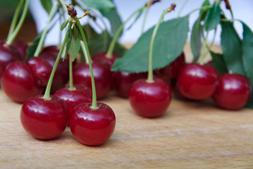 Two ripe juicy cherries on a white surface.