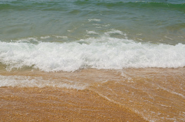 Fototapeta na wymiar Wave on the beach in the deep blue sea