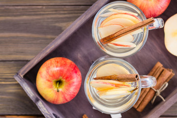 Soothing apple and cinnamon tea in glasses on a wooden table. Detox, antidepressant. Rustic style....