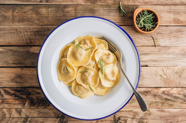Traditional italian ravioli with rosemary and parmesan served onon an enamel plates. Italian pasta.