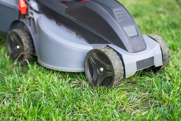 Lawn mower on a lawn in the garden. Gardening background