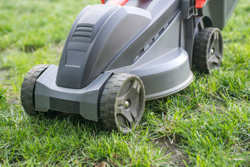 Lawn mower on a lawn in the garden. Gardening background