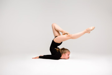 young beautiful girl gymnast on a white background. a young girl is engaged in gymnastics on a white background.