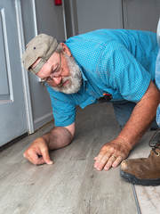 handyman home improvement project laying new vinyl floor