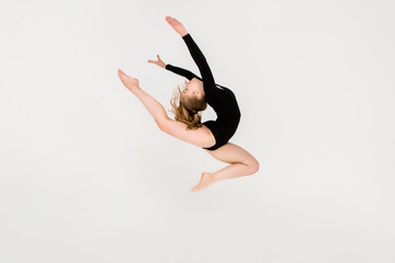Fototapeta premium young beautiful girl gymnast on a white background. a young girl is engaged in gymnastics on a white background.