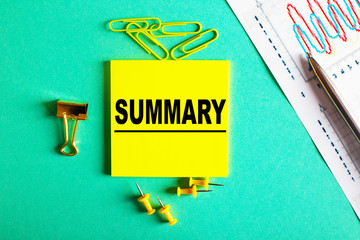 The word resume is written on a yellow background, next to diaries, paper clips, and graphs