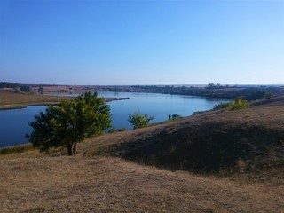 View of the blue water of the lake from the hills of the shore