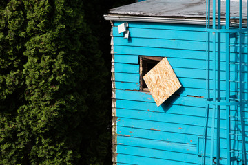 Boarded up window on an abandoned house, with space for text on the left