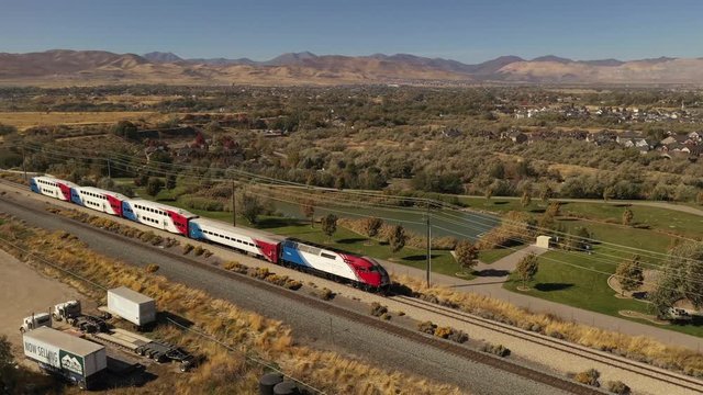 Aerial of train going through suburban town in western United States