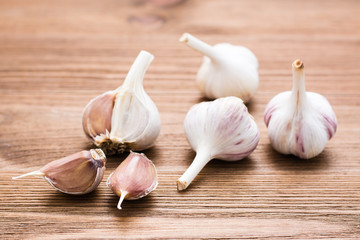 Garlic bulbs whole and lobed on a wooden table. Alternative medicine