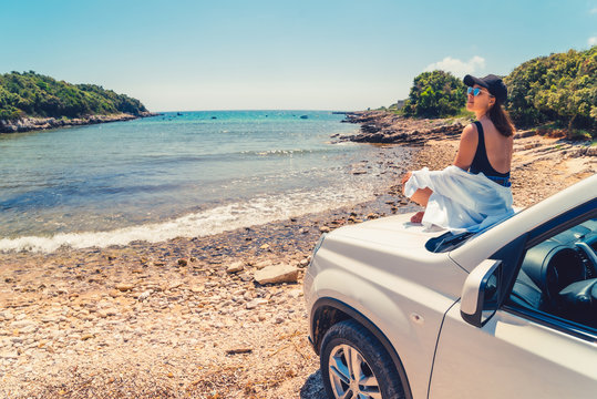 woman laying at car hood with view of sea summer beach
