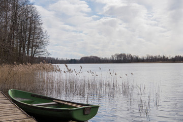 Obraz premium Old boat on lake. Cloudy Spring Day.