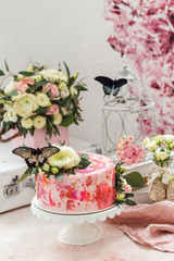 Pink cake decorated with flowers and real butterflies rose romantic atmosphere