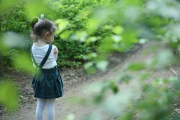 Little girl hug herself. Child alone in the forest. Unattended child. Offended girl.Тhe little girl was lost alone in the forest. 