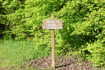 The old wood trail sign on the trail in the park.