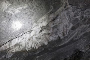 Stalactites hanging from the ceiling of the cave underground. Mountain nature. Habitat of bats.