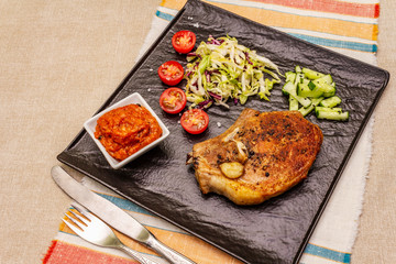 Grilled pork steak. Cole slow salad, tomato sauce, fresh vegetables