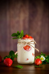 sweet homemade yogurt with ripe fresh strawberries in a jar