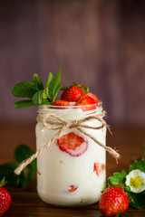 sweet homemade yogurt with ripe fresh strawberries in a jar