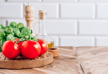 Olive oil, tomato and basil on rustic wooden table. Italian cuisine concept. Ready for cook