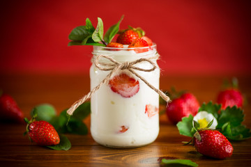 sweet homemade yogurt with ripe fresh strawberries in a jar