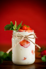 sweet homemade yogurt with ripe fresh strawberries in a jar