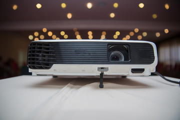 LCD Projector technology video presentation and home Entertainment object . mini led projector on wood table in a room projector home theater idea and concept . Close up projector in conference room .