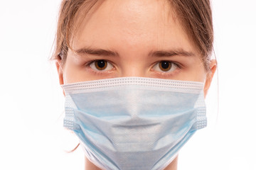 girl with a medical mask on her face looks forward