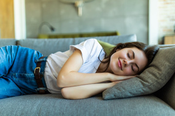 Young sleeping woman is lying on a pillow on a couch