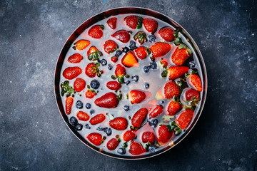 Strawberries in the water. Fresh strawberries in a bowl with water on a dark background. Summer and food art concept.