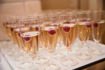 Champagne glasses with raspberries, toast at the wedding