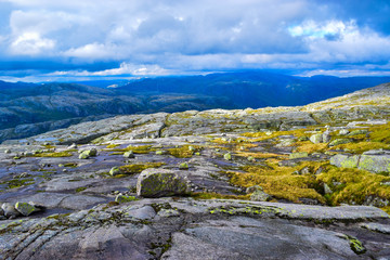 Fototapeta na wymiar Trail to Kjeragbolten. Landscapes of the Norwegian mountains, where the famous boulder stuck at an altitude of 984 meters above Lysefjorden on Mount Kjerag, Norway