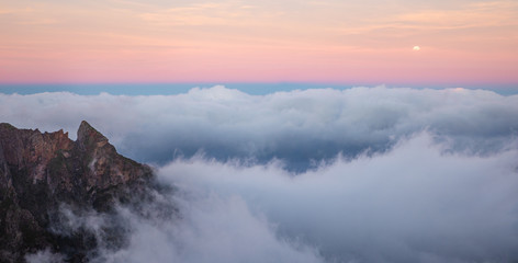 Beautiful cloudy mountains sunset view, clouds above mountain peaks with bright sky background