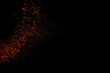Fototapeta na wymiar Red paprika spices powder explosion, flying chili pepper isolated on black background. Splash of spice background.