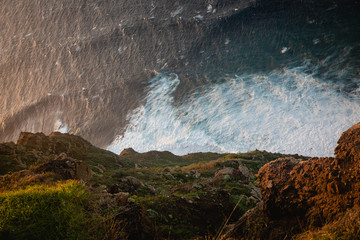 Beautiful scenic sunset view on cliffs coast of Atlantic Ocean with blue breaking waves in Madeira...