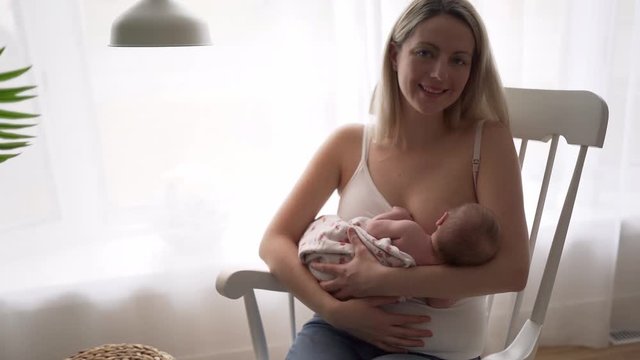 A Mother breastfeeding her little baby girl in her arms.