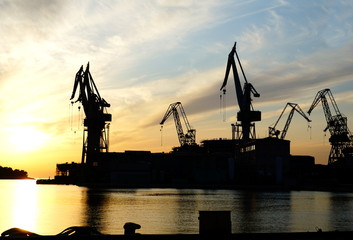 Silhouette of a shipyard on the seashore at dusk