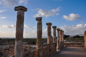 Archeological Park Kato Paphos and columns of House of Theseus on the sunset under the blue sky with fluffy clouds.