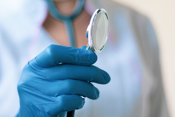 doctor's hand in a medical glove holds a phonendoscope. medical concept