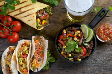 fajitas, burritos, tacos with salsa and a glass of beer