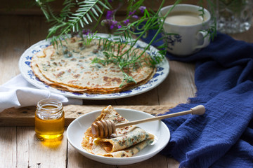 Nettle and spinach pancakes served with honey and coffee. Rustic style.